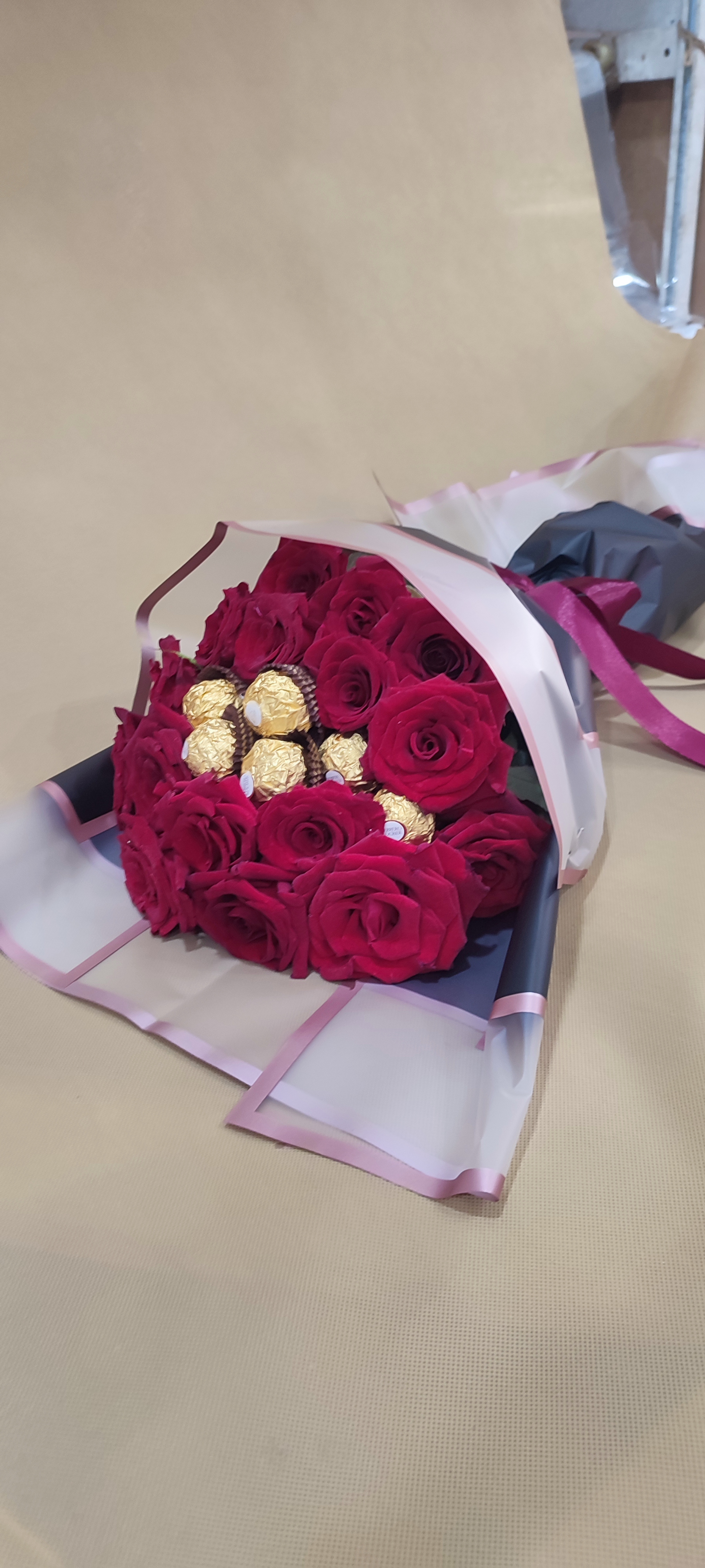 A bouquet of red roses accompanied by chocolate