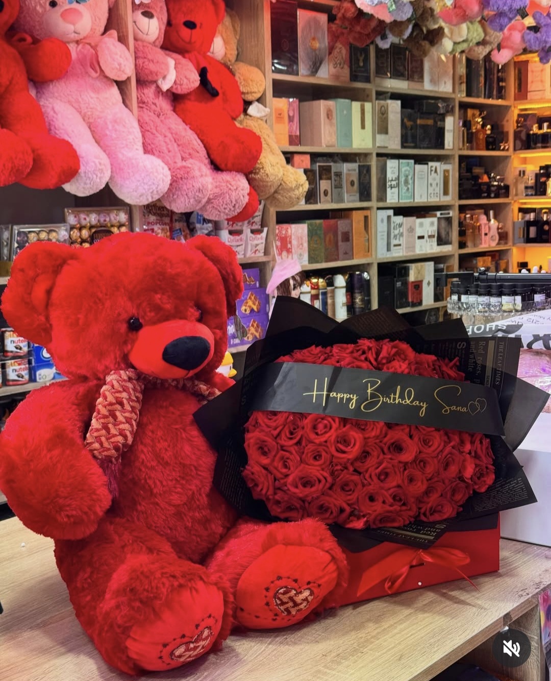 A bouquet of red roses with a red teddy bear